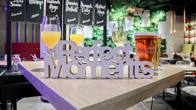 "Perfect Moments"-Schriftzug auf einem Restauranttisch